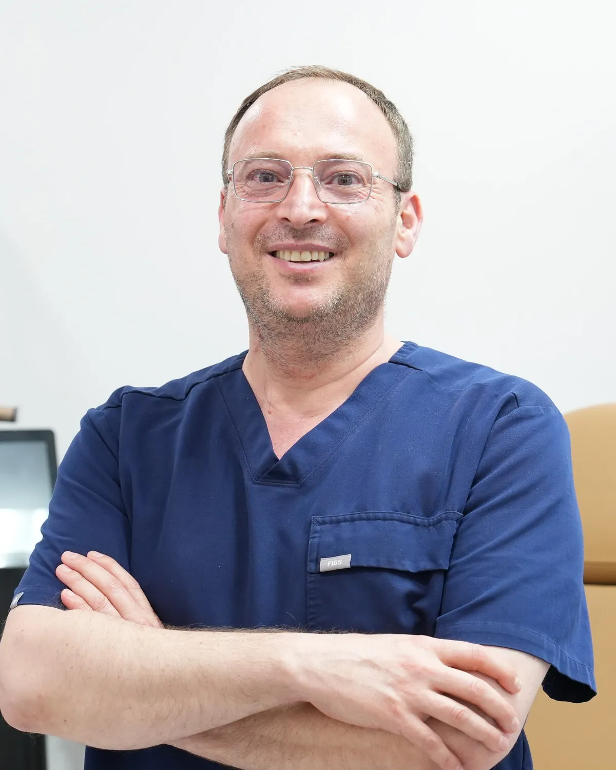 Maher Danhash, MD, board-certified family medicine physician at Elite Family Medical Center, in scrubs at his Upland office