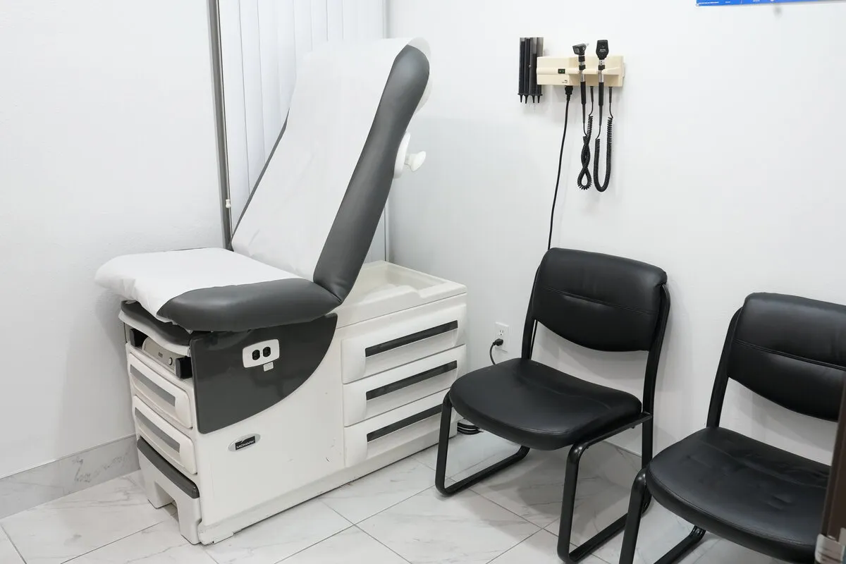 An exam room with an exam table and wall-mounted diagnostic instruments