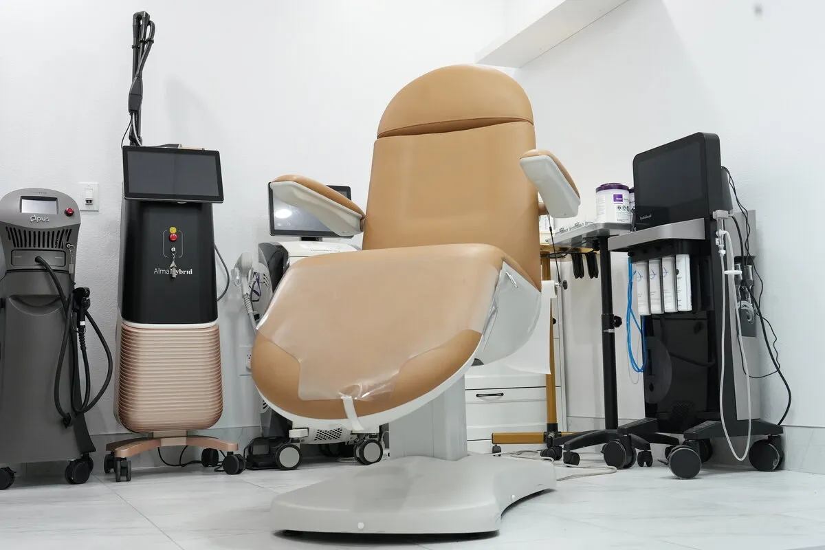 A treatment room with a procedure chair and equipment